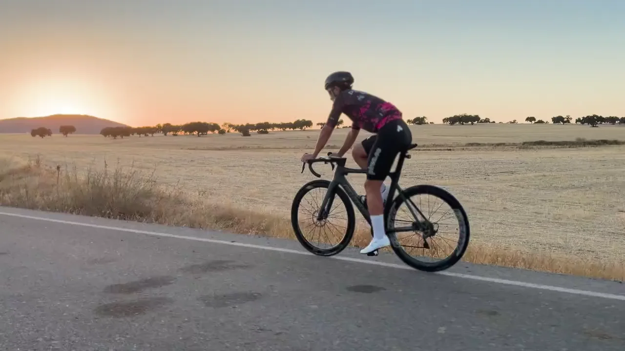 Ciclista de PIREN rodando entre campos al atardecer